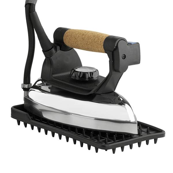 The Reliable Professional Steam Iron 7.5 Long Steam Hose, 220V, with a cork handle and aluminum soleplate in black and silver, rests on a black rubber mat with short upright spikes.